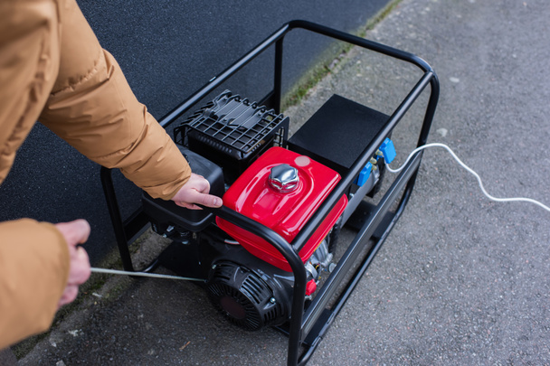 stock-photo-cropped-view-man-starting-electricity-generator-energy-shutdown